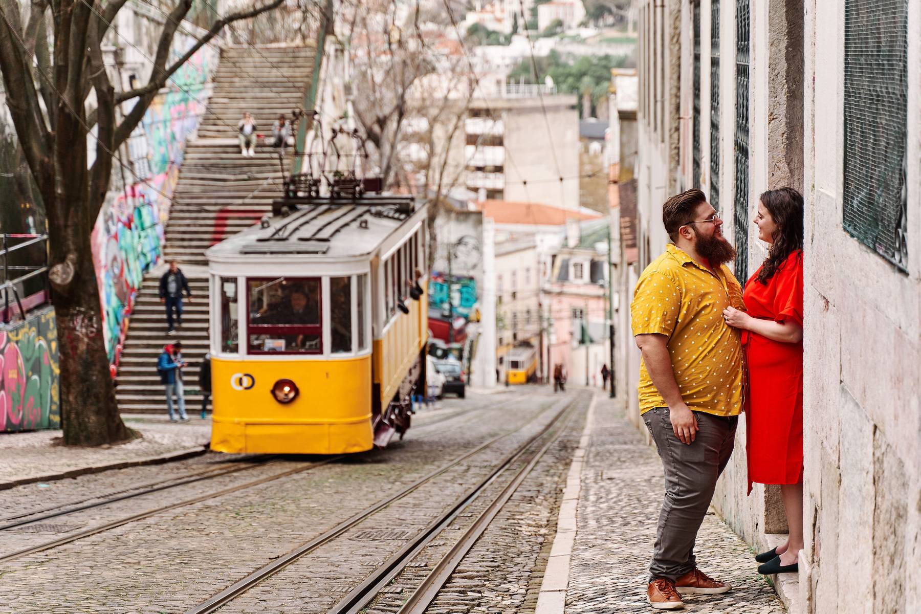 Michele &amp; Josh stand in a doorway with a cable car behind them